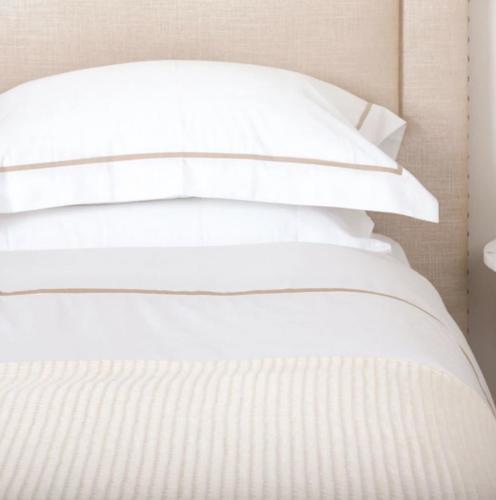 a stack of white pillows on top of a bed at Lady Charlotte's Loft in Schull