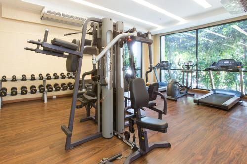 un gimnasio con cintas de correr y equipos de ejercicio en una habitación en Mida Grande Hotel Dhavaravati Nakhon Pathom - SHA PLUS en Nakhon Pathom