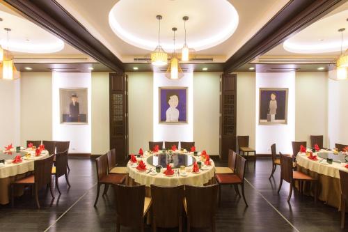 a dining room with tables and chairs and paintings at Mida Grande Hotel Dhavaravati Nakhon Pathom - SHA PLUS in Nakhon Pathom