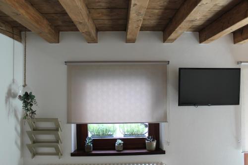 un soggiorno con finestra, tenda e TV di Casa Lia a Cividale del Friuli