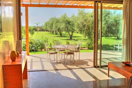 a dining room with a table and chairs on a patio at Villa Jardins D'Isa in Marrakech