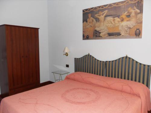 a bedroom with a bed and a painting on the wall at Da Betty in Asti
