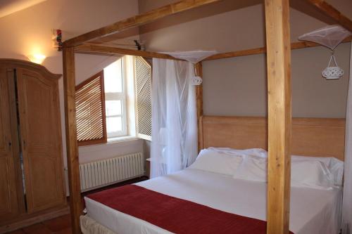 a four poster bed in a bedroom with a window at Hotel La Posada De Alameda in Alameda del Valle