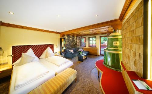 a bedroom with a bed and a living room at Hotel Rebstock Durbach in Durbach