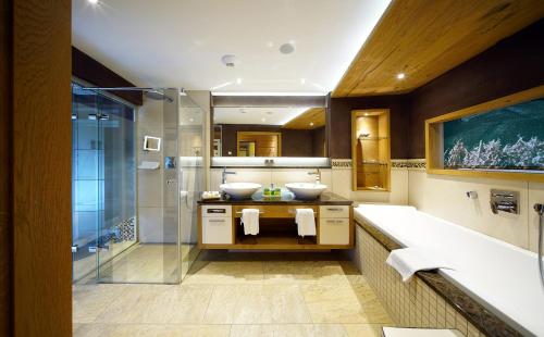a bathroom with two sinks and a shower at Hotel Rebstock Durbach in Durbach