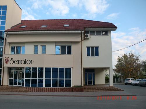 a building with a sign for a dermatologist at Hotel Senator in Slatina