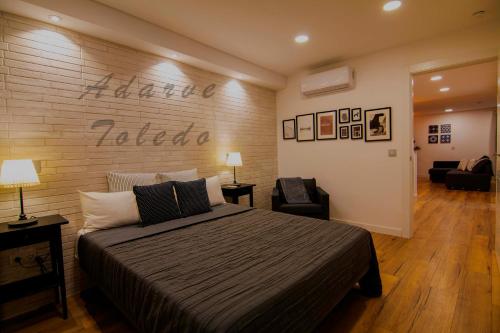 ein Schlafzimmer mit einem Bett und einer Ziegelwand in der Unterkunft Apartamentos Adarve Toledo in Toledo