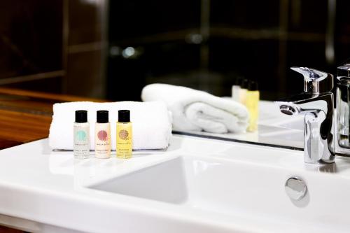 a bathroom sink with two bottles of soap and a mirror at Arlington Hotel O'Connell Bridge in Dublin