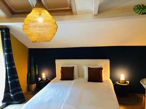 a bedroom with a large white bed with two lamps at Valkenhof in Valkenburg