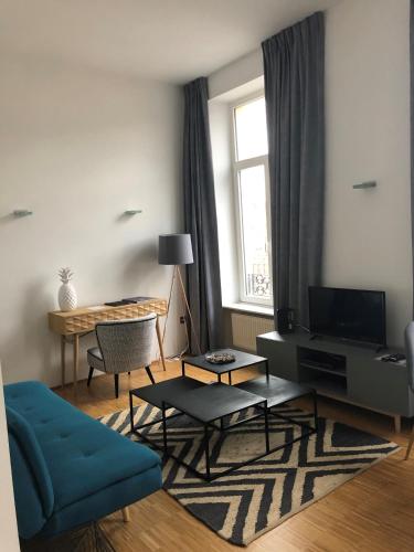 a living room with a blue couch and a window at Hotel Vauban in Luxembourg