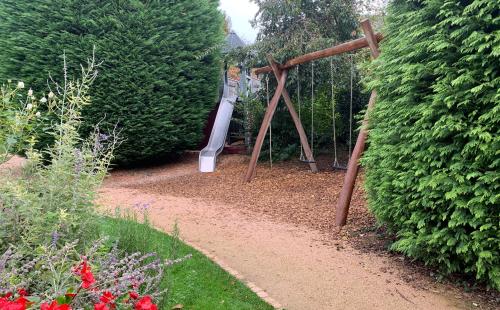 a playground in a garden with a swing at Hotel Rebstock Durbach in Durbach