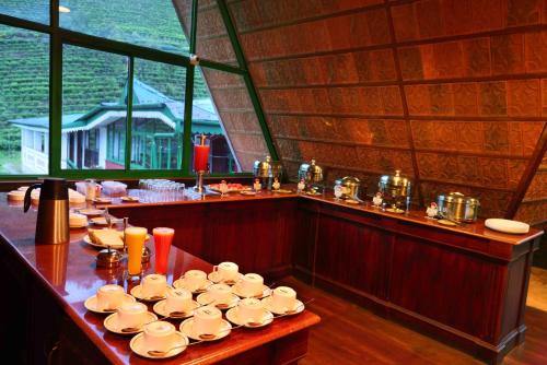 Camelot Resort في مونار: طاولة عليها مجموعة أكواب وصحون