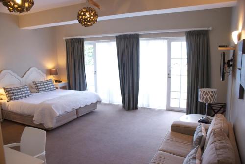1 dormitorio con 1 cama y 1 sofá en Whale Rock Luxury Lodge en Hermanus