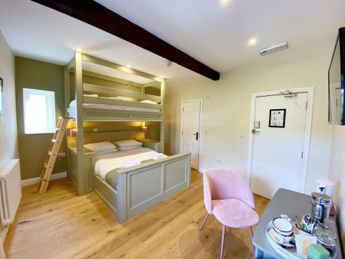 a bedroom with a bunk bed with a desk and a chair at Riverbanc in Llangollen