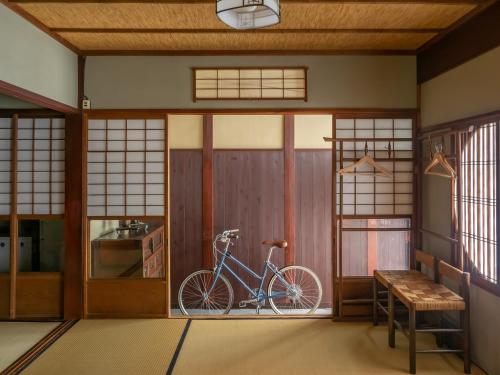 a bike parked in a room with a door at Kyoto Machiya Cottage Karigane in Kyoto