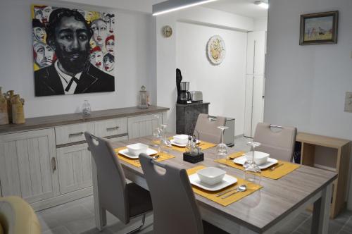 a dining room with a table with chairs and a painting at Residentie Mercator All in Formule in Ostend