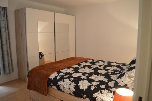 a bedroom with a bed with a black and white blanket at Residentie Mercator All in Formule in Ostend