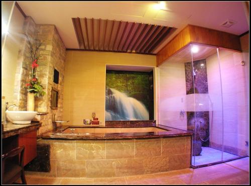 a bathroom with a tub and a sink and a shower at Hakodate Motel in Kaohsiung