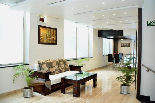 ein Wohnzimmer mit einem Sofa und einem Tisch in der Unterkunft Hotel Surya International in Lucknow