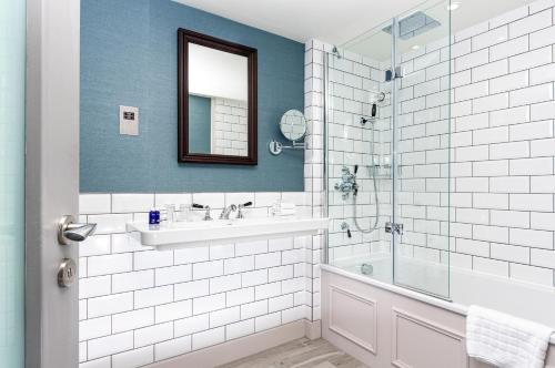 a bathroom with a sink and a glass shower at InterContinental Edinburgh The George, an IHG Hotel in Edinburgh