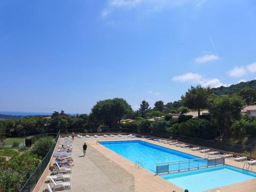 une grande piscine avec des chaises et une personne debout à côté de celle-ci dans l'établissement Petit coin de paradis, à La Croix-Valmer