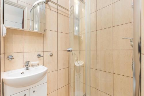 ワルシャワにあるWarsaw Studio Apartment Chmielna by Rentersのバスルーム(洗面台、ガラス張りのシャワー付)