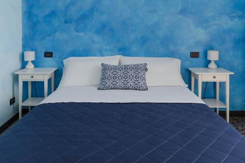 ジェノヴァにあるB&B Caterinaの青いベッドルーム(白いベッド1台、テーブル2台付)