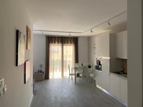 una cucina bianca con tavolo e una sala da pranzo di St Julians Apartment 2 a San Giuliano