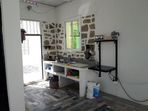 Una cocina blanca con fregadero y ventana. en BELLE MAISON AU COEUR DES MONTAGNES DE TAZA à moins de 10 minutes de l'AGORA PARK, en Taza