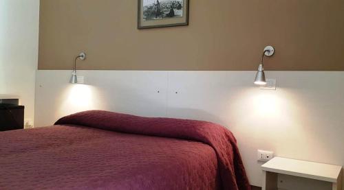 a bedroom with a bed with two lights on the wall at Dépendance Lisa in Pineto