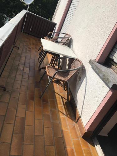 un patio con 2 sillas y una mesa en el balcón en Ferienwohnung Niederfell - An der Mosel en Niederfell