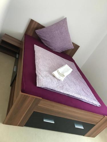 a bed with purple sheets and a napkin on it at Ferienwohnung Niederfell - An der Mosel in Niederfell