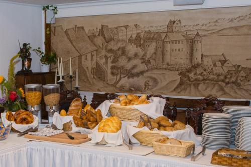 メーアスブルクにあるMittelalterhotel-Gästehaus Rauchfangのパンと皿のバスケットが入ったテーブル