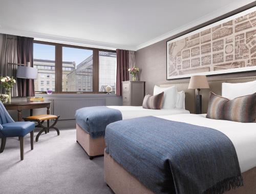 a hotel room with two beds and a desk at InterContinental Edinburgh The George, an IHG Hotel in Edinburgh