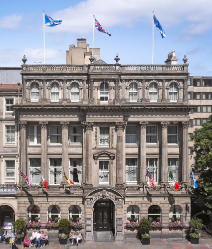 a large stone building with flags in front of it at InterContinental Edinburgh The George by IHG in Edinburgh