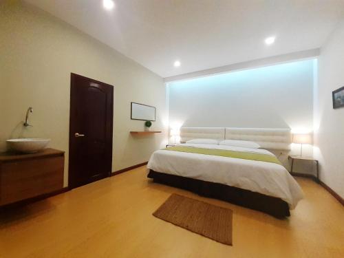 ein Schlafzimmer mit einem Bett und ein Badezimmer mit einem Waschbecken in der Unterkunft Casa D´Cristhi in Puerto Baquerizo Moreno