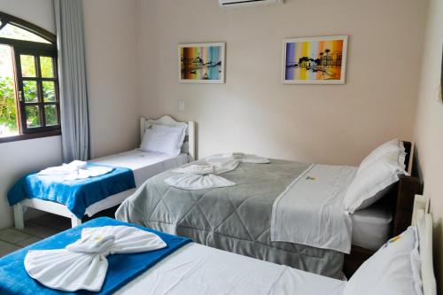 a room with two beds in a room at Hotel Naturalis in Paranaguá