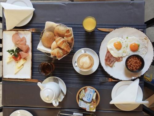 une table garnie d'assiettes de petit-déjeuner et de café dans l'établissement Palmotta Palace, à Dubrovnik
