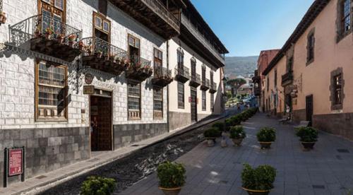 an alley with potted plants on the side of a building at Hotel Rural Victoria - La Orotava in La Orotava