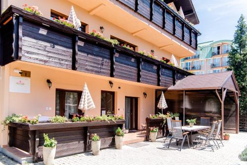 a building with a patio with a table and chairs at Három a Kislány Panzió in Hévíz