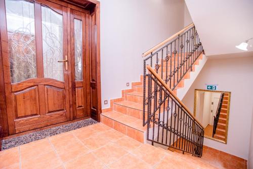 a hallway with a wooden door and stairs at Három a Kislány Panzió in Hévíz