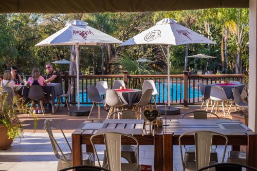 a patio with tables and chairs and umbrellas at Kruger Park Lodge Unit No. 608B in Hazyview