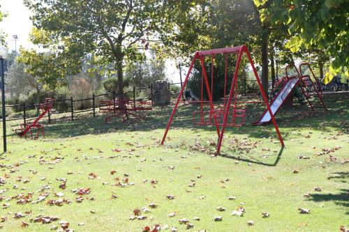 a park with a bunch of playground equipment in the grass at Agriturismo Verbena in Castiglione del Lago