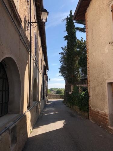an empty alley with a building and a tree at Sun Garda in Ponti Sul Mincio