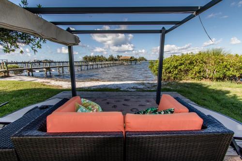 eine Terrasse mit Stühlen und Blick auf das Wasser in der Unterkunft Island View Cottages Sebastian in Sebastian