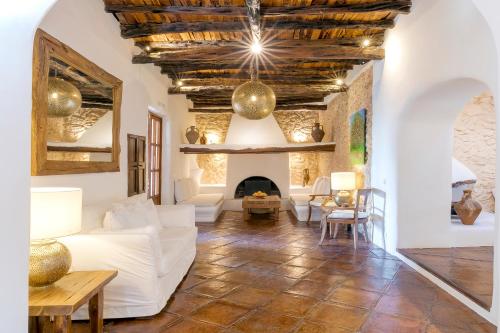 a living room with a white couch and a fireplace at Agroturismo Atzaró in Santa Eularia des Riu