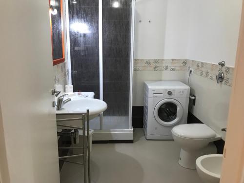 y baño con lavadora y lavadora. en Le Casuzze del Residence Lido Burrone en Favignana