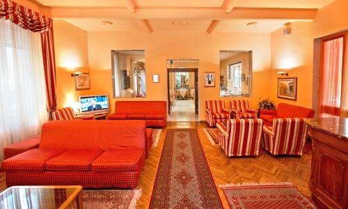 a living room with red furniture and orange chairs at Albergo Nazionale in Salsomaggiore Terme