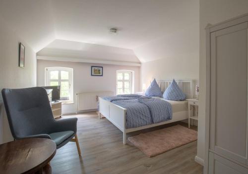 ein Schlafzimmer mit einem Bett, einem Stuhl und einem Tisch in der Unterkunft Bibis Hus in Pellworm