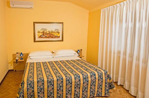 a bedroom with a bed and a window at Albergo Nazionale in Salsomaggiore Terme